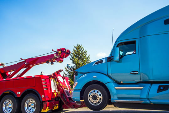 photo of semi truck being towed